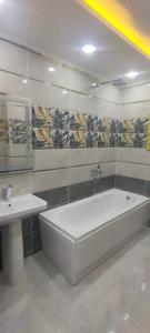 Un baño con bañera blanca y lavabo. en فيلا نون, en El Cairo