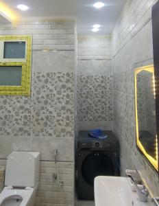 Un baño con inodoro, lavabo y espejo. en فيلا نون, en El Cairo 14 fotos más
