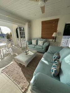 a living room with a blue couch and a table at Mullins Beach Houses in Saint Peter
