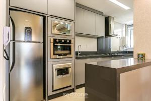 a kitchen with a stainless steel refrigerator and appliances at Sophisticated fit with 3 suites Jurere LES403 in Florianópolis