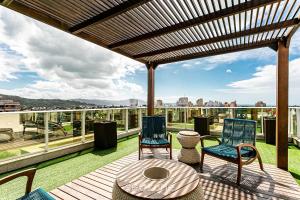 a patio with chairs and a table on a roof at Sophisticated fit with 3 suites Jurere LES403 in Florianópolis