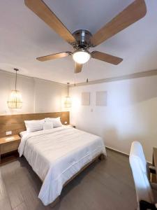 克雷塔罗Modern Apt with Workspace in Central Queretaro的一间卧室配有一张大床和吊扇