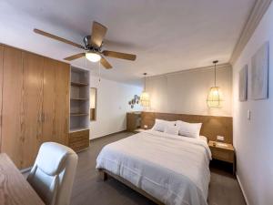 een slaapkamer met een bed en een plafondventilator bij Modern Apt with Workspace in Central Queretaro in Querétaro