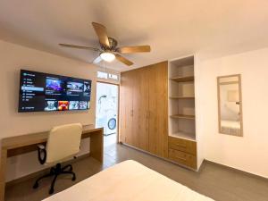 克雷塔罗Modern Apt with Workspace in Central Queretaro的一间卧室配有书桌和吊扇