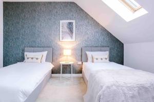 due letti in una stanza con pareti blu di Spacious 4-Bed Manchester Home a Manchester