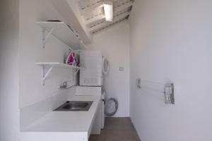 a white bathroom with a sink and a toilet at Serenity Villa in Mosteiros +20 photos