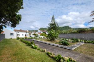 a garden with a house and a tree at Serenity Villa in Mosteiros