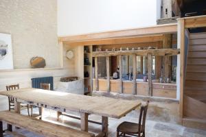 una sala da pranzo con tavolo e sedie in legno di Chambre, sauna, piscine à la campagne a Léguillac de Cercles