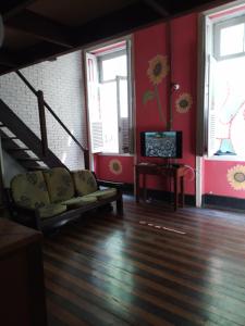 a living room with a staircase and a couch and a television at Lapa Casa Hostel in Rio de Janeiro