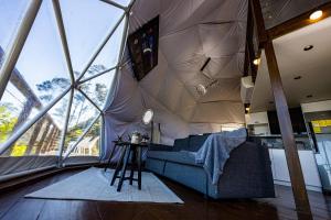 a room with a couch in a large room with huge windows at The Domes Jarabacoa in Jarabacoa