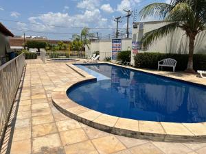 a swimming pool with blue water in a yard at Impera House 2 km do centro in Imperatriz