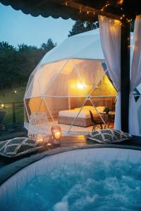 a tent with a bed and a swimming pool at Kallias Dome Resort in Sovata