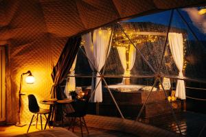 a room with a window with a bed and a table at Kallias Dome Resort in Sovata