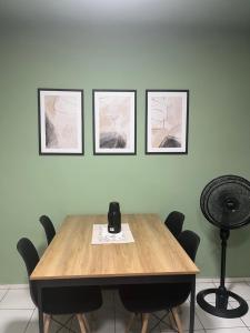 a dining room table with four pictures on the wall at Impera House 2 km do centro in Imperatriz