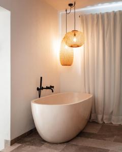 ハベアにあるCa Jardi, Luxury Ibiza-Style villa with private pool, Javeaのバスルーム(白いバスタブ、照明器具付)