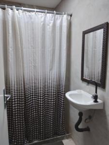 a bathroom with a shower curtain and a sink at Lapa Casa Hostel in Rio de Janeiro