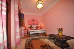 1 dormitorio con 1 cama y 1 mesa en una habitación en Riad La Famille, en Marrakech