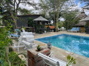 a swimming pool with two lawn chairs and a table at Nzuri House in Nairobi