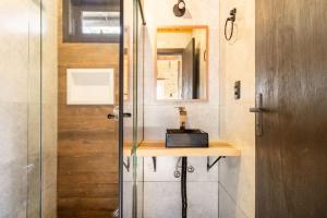 a bathroom with a shower with a sink and a mirror at Vivenda Cambuim do Mundo Novo in Urubici