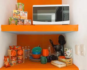 a microwave sitting on top of a shelf at Alberca-Privacidad-Confort in Mérida +18 photos