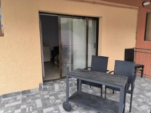 een houten tafel en 2 stoelen op een patio bij CASA RAIA in Braşov