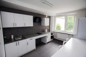 a kitchen with white cabinets and a sink and a window at Klimczoka 6 in Katowice