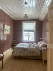 a bedroom with a large bed and a window at Historisk villa med klassiske detaljer in Snertingdal