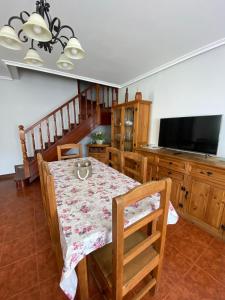 a dining room with a table and a flat screen tv at CHALET FAMILIAS 10 Huéspedes Beranga Noja Playas, Mascotas bienvenidas in Beranga