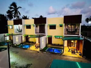a house with two swimming pools in front of it at Duplex Villas Areias do Patacho - Praia do Patacho - Porto Pedras in Pôrto de Pedras