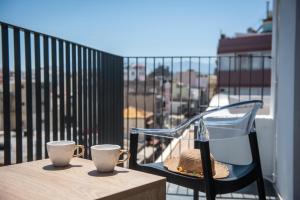 a hat and two cups on a table on a balcony at King's Blue , Superior Living in Heraklio Town