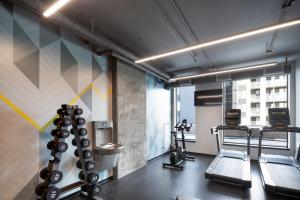 a gym with tread machines and a wall mural at Alt Hotel Calgary University District in Calgary