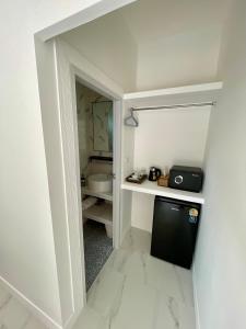 a small kitchen with a small refrigerator in a room at Pavana Boutique & Kite Bungalows in Thongsala
