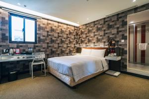 una camera da letto con un letto, una scrivania e una finestra di Hotel Puri Taipei Station Branch a Taipei