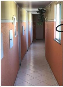 a hallway in a building with orange walls and a tile floor at Hotel Fascinio-Adults Only in Salvador