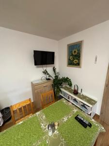 a living room with a table and a tv at Apartmán pod kostelem in Strážov