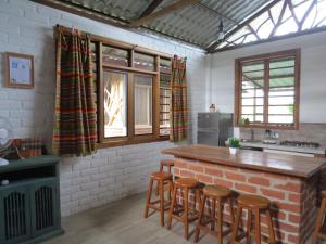 a kitchen with a counter and stools in a room at Hogar&Selva, casa vacacional in Tena