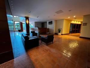 una hall con divano e sedie in un edificio di Vista Azul Apart Hotel - Pedra Azul pinheiros a Pedra Azul