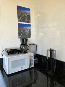 un microondas sentado en la parte superior de un mostrador en LK Lourdes 5, en Belo Horizonte 22 fotos más