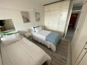 a bedroom with two beds and a mirror at Chasing The Sun in Durban