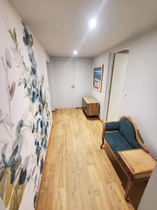 a living room with a blue couch and a wooden floor at Sur le chemin du Cens in Orvault