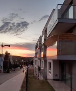 ein Gebäude auf einer Straße mit Sonnenuntergang im Hintergrund in der Unterkunft Salon z aneksem w centrum Gdyni niedaleko morza! in Wzgórze Nowotki