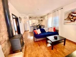 - un salon avec un canapé bleu et une cuisinière dans l'établissement Casa Cesar, à Puntagorda