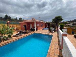 a house with a swimming pool in front of a house at Casa Cesar in Puntagorda