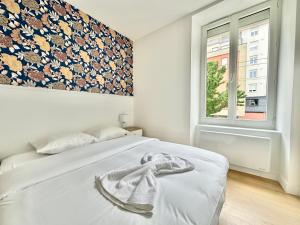 a bedroom with a white bed and a window at Le Renouveau, neuf et tout équipé in Limoges