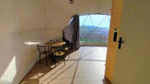 a room with a table and chairs and a large window at Relaksatorium Sfera Beskidu in Sękowa