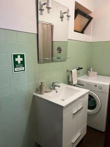 a bathroom with a sink and a washing machine at Discovery Apartment with patio Discovery 2 in Machico