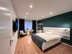a bedroom with a bed and a green wall at Goldstadt Apartments in Pforzheim