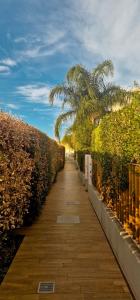 a wooden walkway with a fence and palm trees at Casa Vacanze Rebecca in Pula