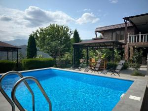 a swimming pool in front of a house at Colibri Hotel in Haghpat