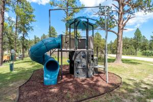 a playground with a blue slide in a park at Little Joy BHBungalows #4 in Custer